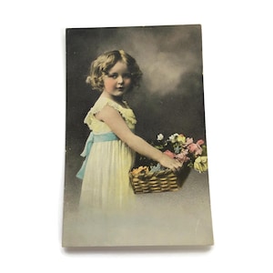Vintage ansichtkaart – handgekleurd meisje met bloemenmand – kortstondig begin jaren 1900
