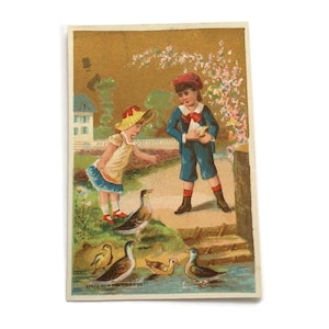 Carte de commerce antique Enfants nourrissant des canards - Scène d'étang vintage avec garçon et fille - Impression du début des années 1900