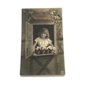 Vintage ansichtkaart – Meisje bij huisje met raam met bloemen – begin jaren 1900