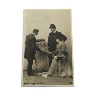 Stara francuska pocztówka fotograficzna – „On songe au nid” – Para wybierająca dywan, początek lat 1900.