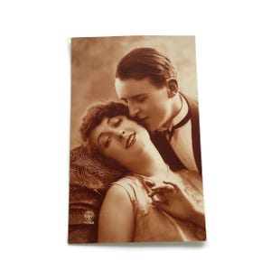 Postal romántica antigua: amantes en un tierno abrazo. Fotografía sepia de principios del siglo XX