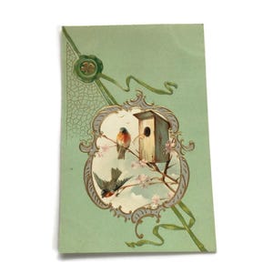 Postal victoriana antigua: casa de pájaros y pájaros cantores en relieve, diseño ornamentado en verde y dorado