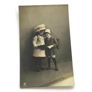 Vintage ansichtkaart – handgekleurde kinderen met boek – antieke schoolscène