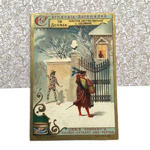 May include: Vintage postcard with a winter scene. The image features a snowy landscape with figures in costume, including a harlequin. Text includes "Carnevals-Serenaden" and "Liebig Company's Fleisch-Extract und Pepton."