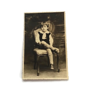 Carte postale photo française - Ancien portrait d'enfant sur une chaise en studio - Début des années 1900