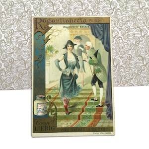 Op de afbeelding: Vintage reclamekaart met een vrouw in een teal jurk en hoed, met twee mannen op de achtergrond. De kaart bevat tekst in meerdere talen, waaronder "Rugantinuccia" en "Liebig Company's Fleisch-Extract". De achtergrond heeft een decoratief patroon.