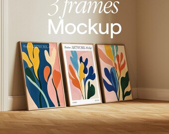 May include: Three framed abstract art prints with a pink, blue, green, and yellow colour scheme. The prints are hanging on a white wall with a wooden floor.