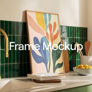 Puede incluir: Una impresión de arte abstracto enmarcada con un diseño floral colorido en tonos de rosa, amarillo, azul y verde. El marco es de madera natural y tiene un diseño simple y moderno. La impresión está colgada en una pared de azulejos verdes en un entorno de cocina.