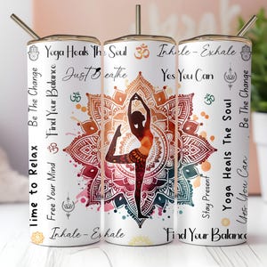 May include: A white tumbler with a gold rim and straw, featuring a yoga-themed design. The design includes a silhouette of a yoga pose, a mandala, and text such as "Yoga Heals The Soul" and "Inhale - Exhale".