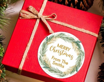 May include: A red gift box with a brown twine bow and a round gift tag that says "Merry Christmas From The Smiths" with a green wreath design.
