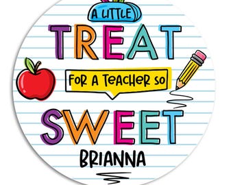 May include: A round, white sticker with a lined paper background. The sticker features colorful text that reads "A LITTLE TREAT FOR A TEACHER SO SWEET BRIANNA" with an apple and pencil illustrations.
