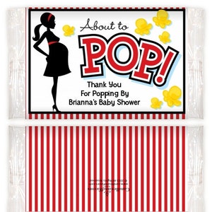 May include: Baby shower favor bag with a red and white striped design. The top features a black silhouette of a pregnant person, yellow popcorn graphics, and the text "About to POP!" in red and white.