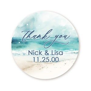 May include: Round thank you sticker with a watercolor design of a beach scene. The sticker says "Thank you" in cursive script and "Nick & Lisa 11.25.00" in a sans-serif font.