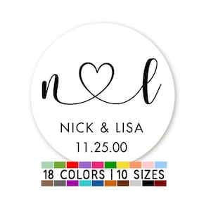 May include: White round sticker with black text and a heart design. The text reads "n & l" with "NICK & LISA" and "11.25.00" below the heart.