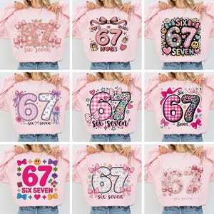 May include: A collection of pink sweatshirts with the number 67 and the words "six seven" printed on them. The designs include floral patterns, bows, hearts, and other decorative elements. The sweatshirts are displayed on a person.