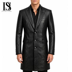 May include: A black long coat featuring a textured snakeskin pattern, a notched lapel, and three front buttons. The coat is worn over a black button-down shirt. The logo IS DYSTRA STORE is visible in the upper left corner of the image.