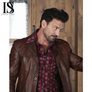 May include: A brown leather jacket with a button closure, worn over a patterned shirt with a red background and geometric shapes. The shirt's collar is visible. The image includes the text "DYSTRA STORE".