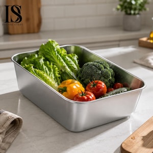 Pode incluir: Um recipiente retangular de metal escovado cheio de produtos frescos. O recipiente contém alface verde, brócolis, pimentões amarelos, tomates vermelhos e pepinos. O texto "IS OYSTRA STORE" está no canto superior esquerdo.