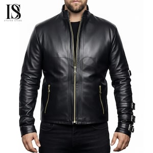 Op de afbeelding: Zwarte leren jas met een opstaande kraag en een lange gouden ritssluiting. De jas heeft gouden ritsen op de zakken en drie gespriemen op de linkermouw. De jas is van Dystra Store.