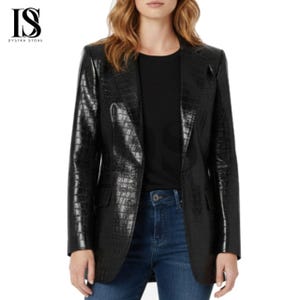 May include: A black blazer with a crocodile texture. The blazer has a classic notched lapel, two front pockets, and a single-button closure. The blazer is worn over a black top and blue jeans. The logo "IS DYSTRA STORE" is in the top left corner.