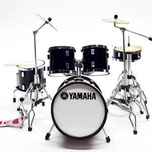 May include: A miniature black Yamaha drum set with a white bass drum, cymbals, and stands.