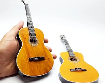 Guitarra acústica clásica en miniatura, hecha a mano en madera natural de caoba, ideal como recuerdo musical, regalo o decoración.