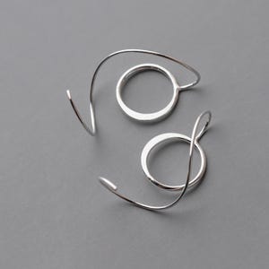 cool silver earrings shown against a gray background