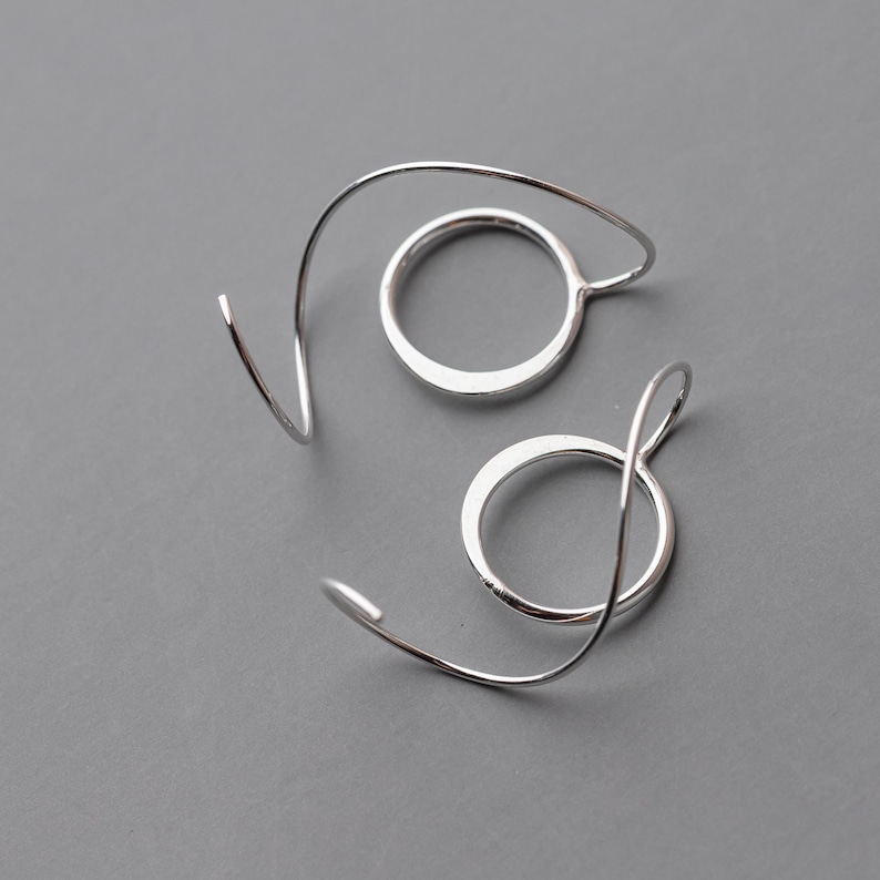 cool silver earrings shown against a gray background