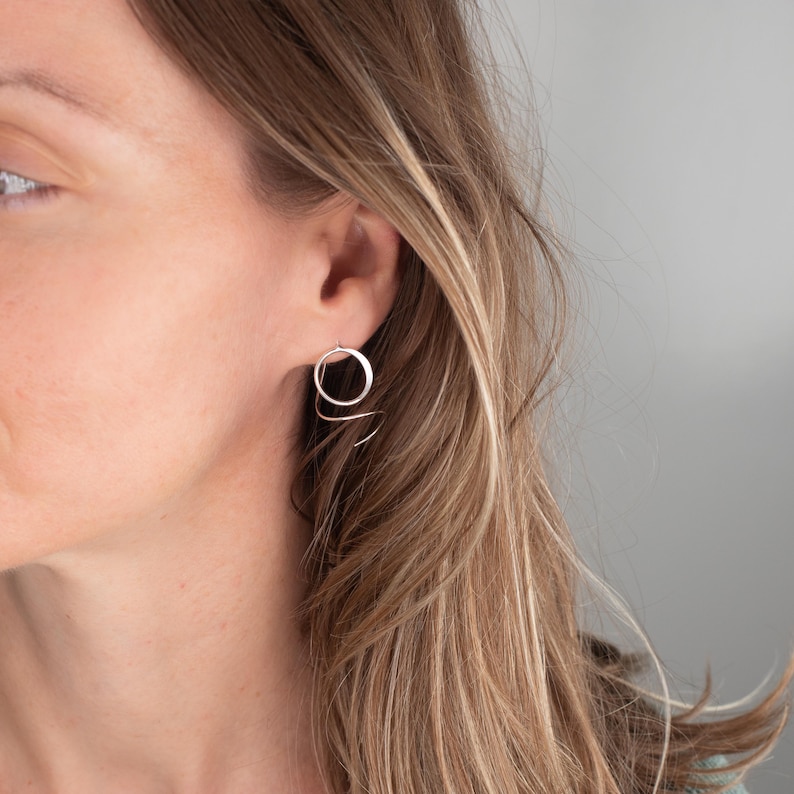 Close up photo of silver threader earrings shown being worn on a model.