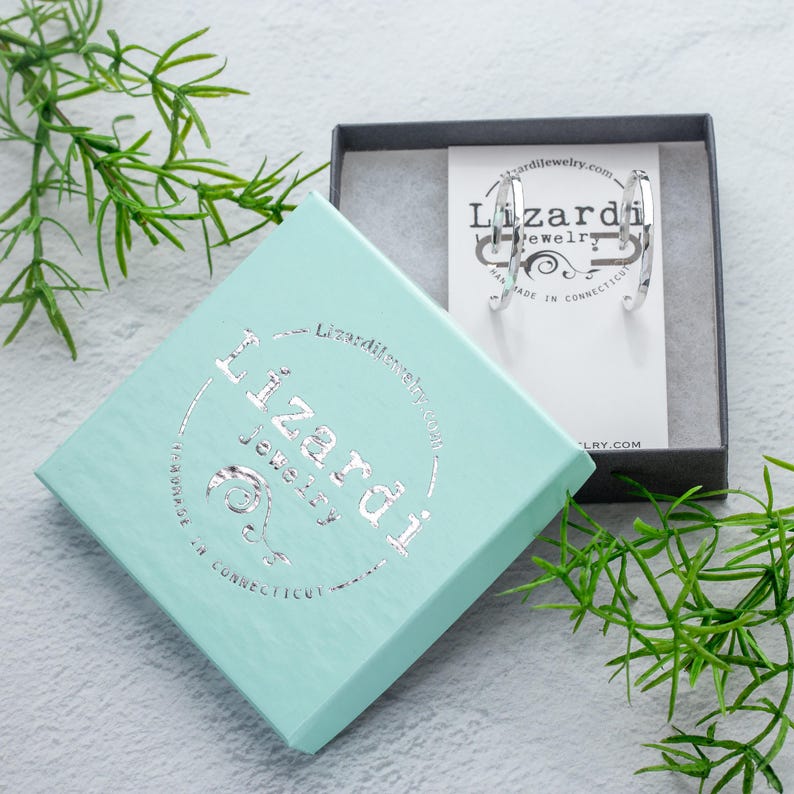 K&ouml;nnte beinhalten: Silberne Creolen in einer t&uuml;rkisfarbenen Box mit dem Text "Lizardi Jewelry" und "Handmade in Connecticut" auf der Box.