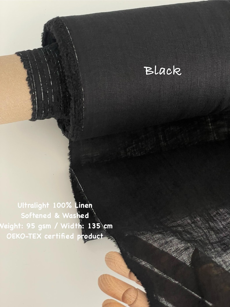 May include: A roll of black ultralight 100% linen fabric. The fabric is softened and washed, with a weight of 95 gsm and a width of 53 inches. The text "Black" is visible on the fabric. The product is OEKO-TEX certified.