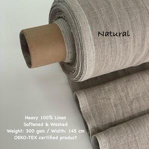 May include: A roll of natural-colored, heavy 100% linen fabric. The fabric is softened and washed, with a weight of 300 gsm and a width of 145 cm. The text "Natural" is visible on the fabric. The product is OEKO-TEX certified.
