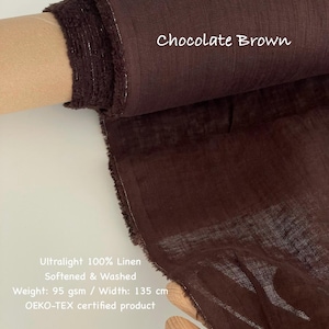 Op de afbeelding: Een rol ultralichte, chocoladebruine 100% linnen stof. De stof is verzacht en gewassen, met een gewicht van 95 g/m&sup2; en een breedte van 135 cm. De tekst "Chocolate Brown" is zichtbaar.