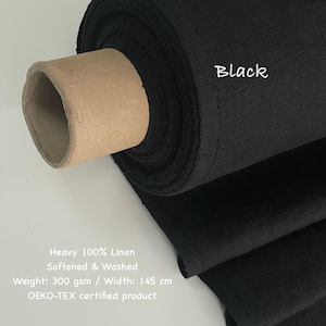 May include: A roll of black linen fabric. The text "Black" is written on the fabric. The fabric is labeled as heavy 100% linen, softened and washed, with a weight of 300 gsm and a width of 145 cm. It is an OEKO-TEX certified product.