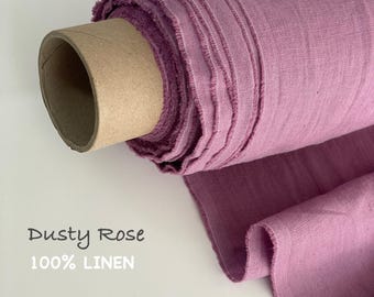 Op de afbeelding: Een rol stof in oudroze kleur gewikkeld rond een kartonnen koker. Het textiel heeft een zichtbare geweven textuur en is gelabeld als 100% linnen. De stof is aan de onderkant iets uitgerold, waardoor de plooi en de rauwe rand zichtbaar zijn.