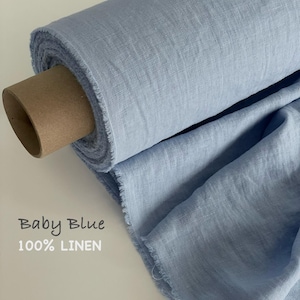 Peut inclure: Un rouleau de tissu en lin 100% bleu bébé avec une texture tissée visible et des bords effilochés. Le tissu est enroulé autour d'un tube en carton marron. Le texte Baby Blue 100% LINEN est imprimé sur le côté gauche dans une police simple.