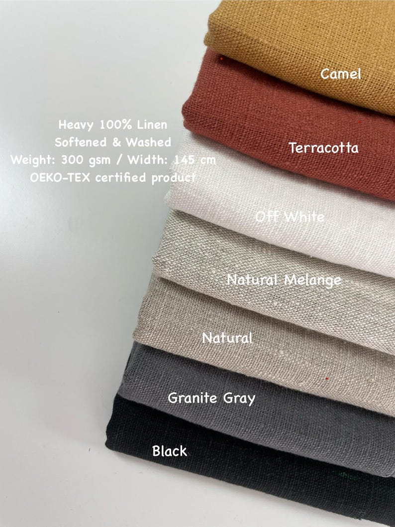 May include: A stack of linen fabric samples in various colors, including camel, terracotta, off-white, natural melange, natural, granite gray, and black. The fabric is labeled as heavy 100% linen, softened, and washed, with a width of 145 cm.