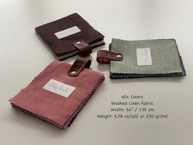 May include: Three stacks of square linen fabric swatches in clay pink, dark brown, and sage green. Each stack is secured with a brown leather tab and a gold metal rivet. Text reads: 40+ Colors, Washed Linen Fabric, Width: 54" / 135 cm, Weight: 6.78 oz/yd2 or 230 gr/m2.
