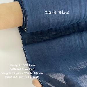 May include: A roll of dark blue ultralight 100% linen fabric. The fabric is softened and washed, with a width of 135 cm. The text "Dark Blue" is visible on the fabric. The fabric is an OEKO-TEX certified product.