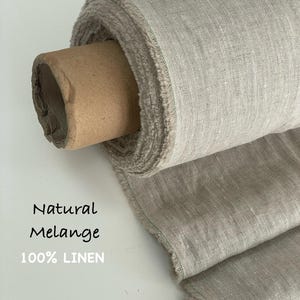 May include: A roll of natural melange 100% linen fabric with a visible woven texture and frayed edges. The fabric is wrapped around a brown cardboard tube. The text Natural Melange 100% LINEN is printed on the left side of the image.