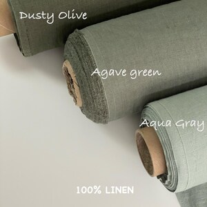 Może przedstawiać: Trzy rolki tkaniny 100% lnianej w r&oacute;żnych odcieniach zieleni. G&oacute;rna rolka jest oznaczona jako Dusty Olive, środkowa jako Agave green, a dolna jako Aqua Gray. Każda rolka ukazuje charakterystyczną, teksturowaną strukturę splotu tkaniny.