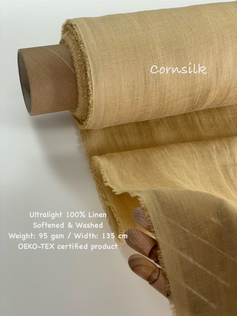 May include: A roll of cornsilk-colored, ultralight 100% linen fabric. The fabric is softened, washed, and measures 53 inches wide. The text "Cornsilk" is visible on the fabric. The product is OEKO-TEX certified.