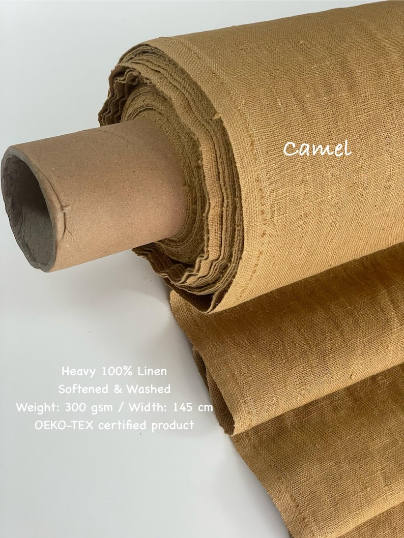 May include: A roll of camel-colored heavy 100% linen fabric. The fabric is softened and washed, with a weight of 300 gsm and a width of 145 cm. The text "Camel" is visible on the fabric. The product is OEKO-TEX certified.