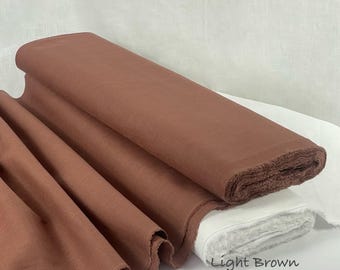 Op de afbeelding: Een rol lichtbruine 100% linnen stof, gevouwen en gedrapeerd. Het textiel heeft een zichtbare geweven structuur en een matte afwerking. De tekst "Light Brown 100% Linen Fabric" staat in de rechterbenedenhoek van de afbeelding.