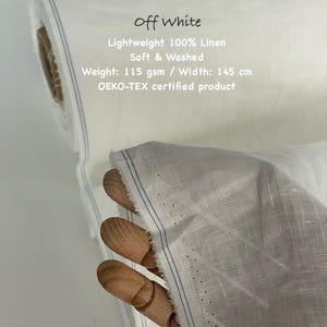 Puede incluir: Rollo de tela de lino 100% ligero y blanquecino. La tela es suave, lavada y con certificaci&oacute;n OEKO-TEX. El ancho es de 145 cm. El texto de la imagen dice "Off White, Lightweight 100% Linen, Soft & Washed."