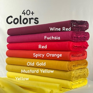 K&ouml;nnte beinhalten: Ein Stapel von Stoffballen in einem Farbverlauf, darunter Weinrot, Fuchsia, Rot, Spicy Orange, Altgold, Senfgelb und Gelb. Der Text 40+ Colors ist oben aufgedruckt, wobei Beschriftungen die jeweilige Farbe des Stoffes genau identifizieren.