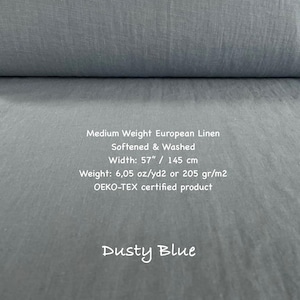 May include: A bolt of dusty blue medium weight European linen fabric. The text reads: Medium Weight European Linen, Softened & Washed, Width: 57", Weight: 6.05 oz/yd2, OEKO-TEX certified product, Dusty Blue.