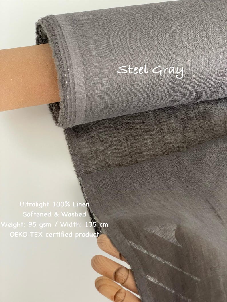 May include: A roll of steel gray ultralight 100% linen fabric. The fabric is softened and washed, with a weight of 95 gsm and a width of 135 cm. The text "Steel Gray" is visible on the fabric. The product is OEKO-TEX certified.