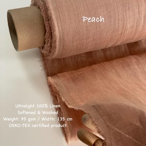 May include: A roll of peach-colored ultralight 100% linen fabric. The fabric is softened and washed, with a weight of 95 gsm and a width of 135 cm. The text "Peach" is visible on the fabric. The product is OEKO-TEX certified.