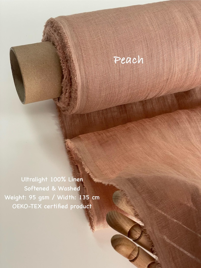 May include: A roll of peach-colored ultralight 100% linen fabric. The fabric is softened and washed, with a weight of 95 gsm and a width of 135 cm. The text "Peach" is visible on the fabric. The product is OEKO-TEX certified.